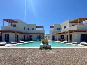 a villa with a swimming pool in front of a building at Dawn Milos in Pollonia