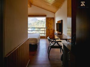 a bedroom with a bed and a desk and a window at The Stone Age : a boutique hotel in Shimla