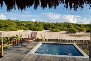 a chair sitting on a deck next to a swimming pool at Pacas Suítes Lençóis Eco Lodge in Santo Amaro