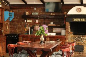 a wooden table with a vase of flowers on it at LA STORIA by Camping Mala in Eşelniţa