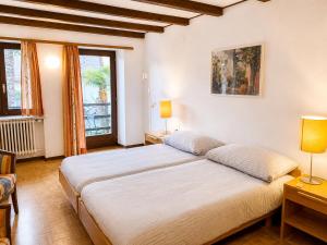 a bedroom with a large white bed and two lamps at Parkhotel Emmaus - Casa Rustico in Ascona +44 photos