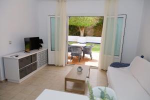 a living room with a couch and a television and a table at Hotel Marazul in Mojácar