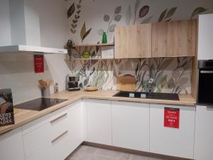 a kitchen with white cabinets and a sink at maison wave in Léon