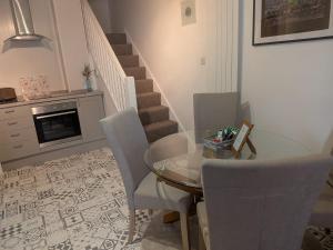 a dining room with a glass table and chairs at Sandham Hall Cottage in Sandown