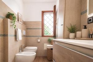 a bathroom with a toilet and a sink and a window at ALBA - Seaview Luxury in San Teodoro
