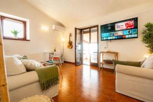 a living room with a couch and a tv on the wall at ALBA - Seaview Luxury in San Teodoro