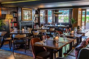 a restaurant with tables and chairs and a fireplace at The Royal Foresters, Ascot, Berkshire - Acorn Pubs in Ascot