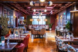 a restaurant with wooden floors and tables and chairs at The Royal Foresters, Ascot, Berkshire - Acorn Pubs in Ascot