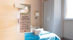a hotel room with a sign on a bed at RossoCorallo in Gallipoli