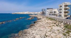 a view of a beach with buildings and the ocean at RossoCorallo in Gallipoli