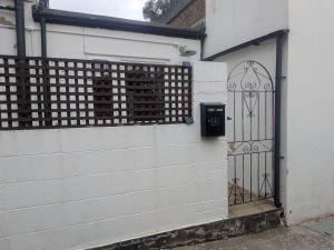 a gate on the side of a building with a white wall at Sandham Hall Cottage in Sandown