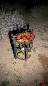a basket filled with tomatoes and other fruits and vegetables at FLORA RUM LUXURY CAMP & Bubble Hotel in Wadi Rum