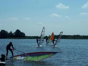 a group of people in the water with windsurfing at Bed & Bike De Hofstee in Giethoorn
