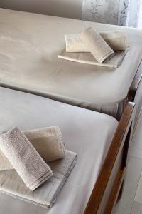 two beds with white sheets and towels on them at Anthema Apartments in Kalogria