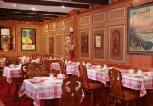 a dining room with tables and chairs in a restaurant at Hotel Restaurant Père Benoît in Entzheim