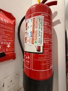 a red fire hydrant is on the wall at غرفتين وصالة النبلاء in Medina