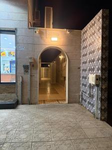 an empty hallway of a building with an archway at غرفتين وصالة النبلاء in Medina