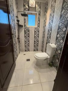 a bathroom with a toilet and a window at غرفتين وصالة النبلاء in Medina
