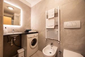 a bathroom with a washing machine and a sink at Pixner Apartments in Bolzano +19 photos