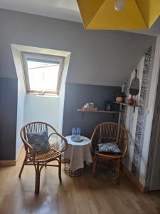 a room with two chairs and a table and a window at chambres évènements circuit LE MANS in La Milesse