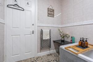 a bathroom with a white door and a sink at 3BR Pontypool Haven - Sleeps 6 with Parking in Pontnewynydd