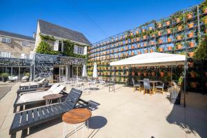 an outdoor patio with chairs and tables and a building at Casa Daupi Hotel Boutique in Mar del Plata