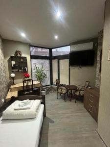 a bedroom with a bed and a desk and a television at Апартамент за гости КРИСИ - Apartment for rent KRISI in Vidin