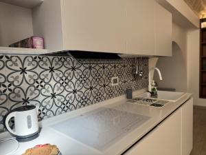 a kitchen with a white counter top and a patterned wall at I quattro Pumi in Mola di Bari