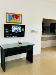 a desk in a room with a tv on the wall at Agbevivi Boutique Hôtel in Aného