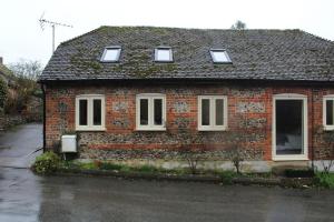 a brick house with four windows on a street at Charming Converted Stable in Ramsbury for Two in Ramsbury