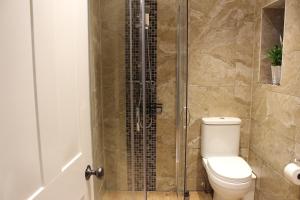 a bathroom with a toilet and a glass shower at Charming Converted Stable in Ramsbury for Two in Ramsbury +12 photos