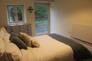 a bedroom with a bed with pillows and a window at Charming Converted Stable in Ramsbury for Two in Ramsbury