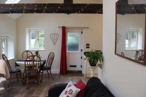 a living room with a table and a dining room at Charming Converted Stable in Ramsbury for Two in Ramsbury