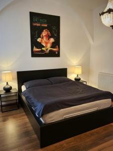 a bedroom with a bed with a poster on the wall at Budyne Apartment II. in Budyně nad Ohří
