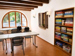 a dining room with a table and chairs and a book shelf at Parkhotel Emmaus - Casa Rustico in Ascona