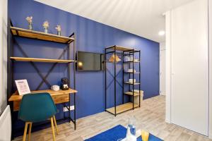 a room with a desk and a blue wall at Studio L'Indigo - F1 design, hypercentre - CAEN in Caen