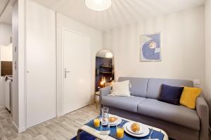 a living room with a couch and a table at Studio L'Indigo - F1 design, hypercentre - CAEN in Caen
