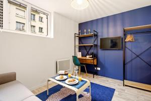 a living room with a blue accent wall at Studio L'Indigo - F1 design, hypercentre - CAEN in Caen