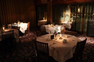 a dining room with tables and chairs with white table cloth at Hotel Åregården in Åre