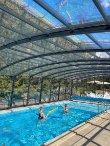 two people in a swimming pool under a canopy at Port Jabłonka in Jabłonka