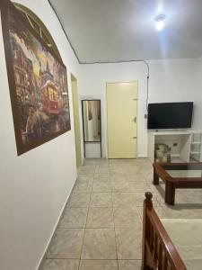 a living room with a table and a tv at Riacho Fundo 1 - Riacho Mall in Brasília