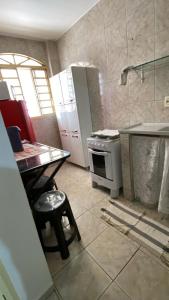 a kitchen with a table and a stove in it at Riacho Fundo 1 - Riacho Mall in Brasília