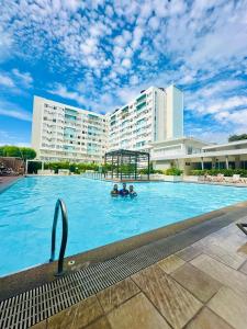 two people in a swimming pool in a hotel at Norman Condominium Unit Rental in Dumaguete