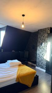 a bedroom with a large bed with a yellow blanket at Au coeur d'Harfleur 2 in Harfleur