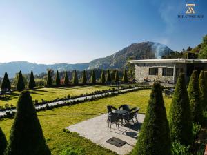 a house with two chairs sitting in a garden at The Stone Age : a boutique hotel in Shimla