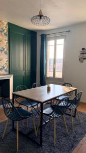 a dining room with a wooden table and chairs at Au coeur d'Harfleur 2 in Harfleur