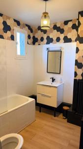 a bathroom with a sink and a tub and a mirror at Au coeur d'Harfleur 2 in Harfleur