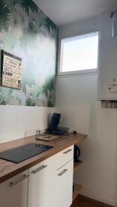 a kitchen with a laptop on a counter and a window at Au coeur d'Harfleur 2 in Harfleur