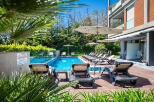 a swimming pool with lounge chairs and an umbrella at Rooms Oasis Life in Split