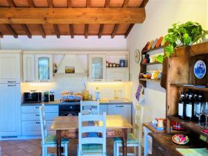 a kitchen with blue cabinets and a wooden table and chairs at Cipressi Rossi in Greve in Chianti